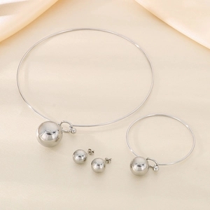 Three-piece silver stainless steel jewelry set featuring hollow ball pendants on silk background