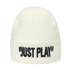 Close-up of white knit beanie featuring black embroidered JUST PLAY text detail
