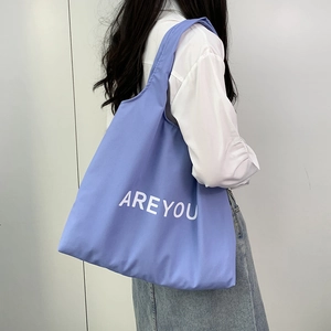 Lavender purple canvas tote bag with AREYOU print worn by model in a minimalist studio