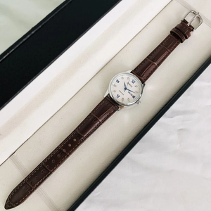 Elegant women's watch with brown leather strap, silver case, and date display