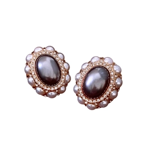 Vintage gold oval earrings with a large grey faux pearl surrounded by crystals and white beads