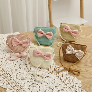 Detailed view of woven straw shoulder bags with polka dot bows and lace in various colors