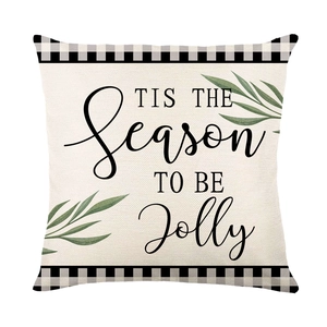Christmas pillow cover with 'Tis the Season' text and green leaves on white linen