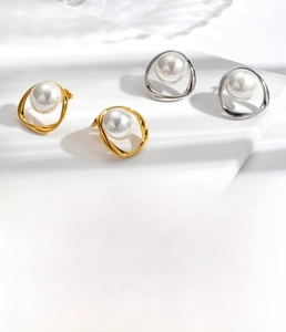Detailed view of luxury titanium steel pearl stud earrings in gold and silver finish