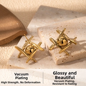 Macro detail of gold geometric earrings with central spheres on a stone base