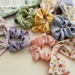 Detail of floral silk scrunchies with long ribbons and vibrant botanical patterns