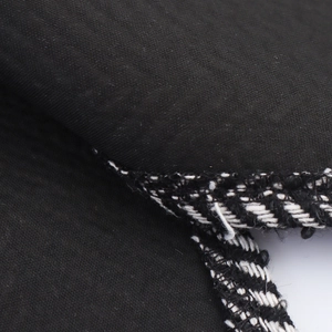 Women's British style tweed coat with black and white woven trim and tie waist details