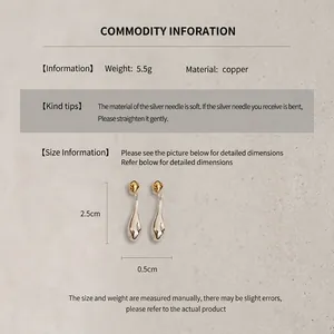 Macro detail of gold plated teardrop earrings with measurements and silver needle texture