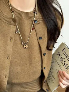Detail of vintage beaded necklace with golden rocking horse pendant and wooden beads