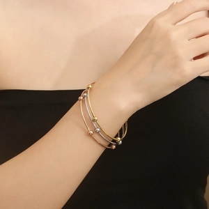 Minimalist stainless steel beaded bangles in gold, silver and rose gold on wrist