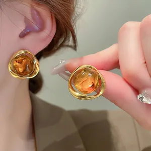Irregular resin geometric stud earrings with gold frame in Maillard amber style