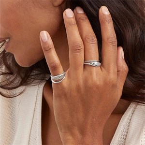 Close-up of stacked silver rings with cocoon texture and fine pave diamond bands