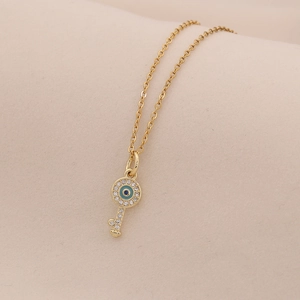 Dettaglio della collana con ciondolo a chiave occhio greco dorata con cristalli
