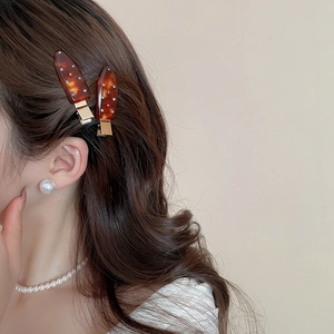 Detail of tortoise shell acrylic hair clips with colorful rhinestones on a model