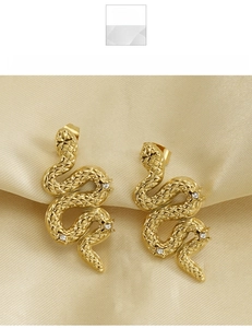 Macro shot of 18K gold snake stud earrings in titanium steel with crystal scales