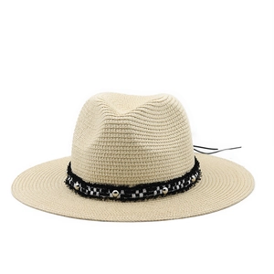 Detail of natural straw fedora with black and white checkered band and silver studs