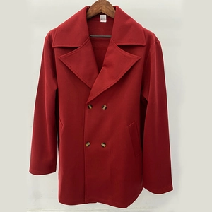 Detail of red double-breasted trench coat featuring wide lapels and knit texture fabric
