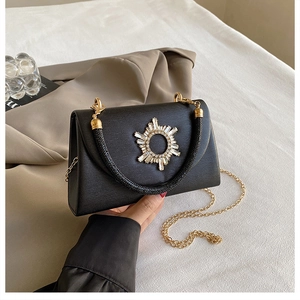 Detail of black pebbled leather crossbody bag with rhinestone star and beaded handle
