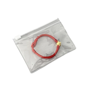 Red braided rope bracelet with golden animal charm in a clear PVC zipper jewelry pouch