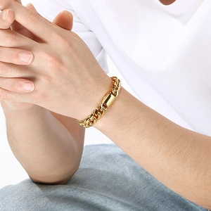 Close-up of a gold stainless steel Cuban link bracelet with a flip-top clasp worn on wrist
