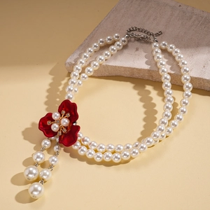 Detail of red enamel flower pendant with pearls on a double-layer vintage necklace