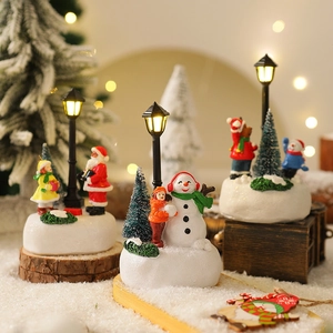 Scena natalizia in miniatura con Babbo Natale, pupazzo di neve e lampione luminoso