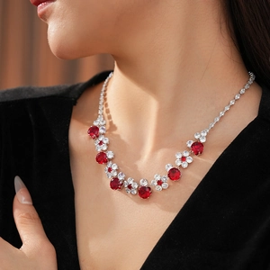Detailed view of luxury zircon flower necklace with red and white stones on a model