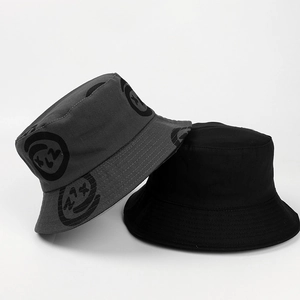 Detail view of cotton bucket hats with graffiti smile print and plain black street style