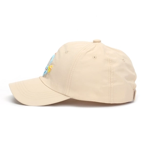 Dettaglio cappellino beige per bambini con ricamo astronauta e fori di ventilazione