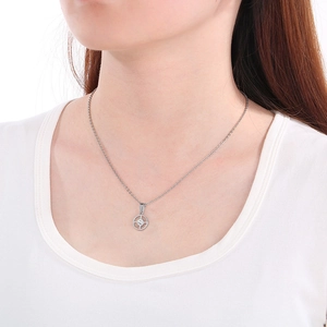 Close-up of geometric circular silver necklace with central zircon on female collarbone