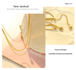 Detailed view of triple-layered golden snake chains with a heart pendant and clasp