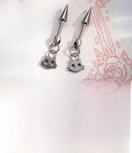 Detailed view of silver titanium cat charm earrings with punk cone design for women
