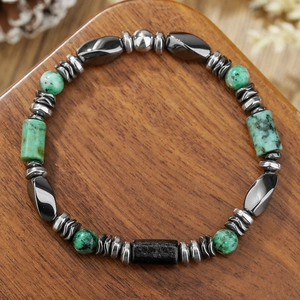 Men's handmade bracelet with turquoise beads and hematite stones on wood base