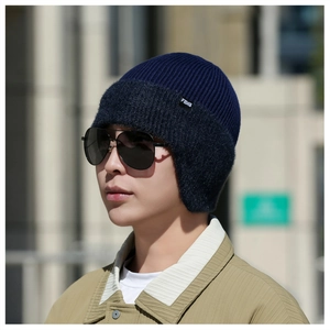 Détail du bonnet en tricot bleu marine avec cache-oreilles et étiquette FBXS