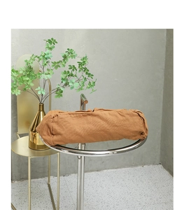 Detail of soft brown washed canvas shoulder bag texture on minimalist display stand