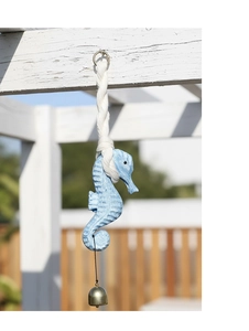 Detail of seahorse wind chime with rustic blue texture and small bronze bell on rope