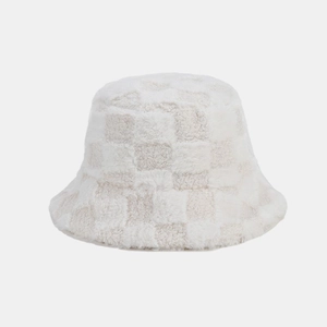 Dettaglio del cappello a secchiello in morbido peluche a scacchi con texture in pelliccia