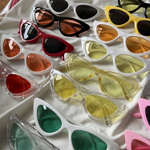 Flat lay of colorful cat eye sunglasses in vibrant candy colors on white fabric