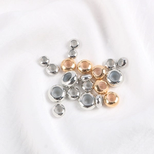 Perles d'arrêt polies dorées et argentées avec insert silicone sur satin blanc