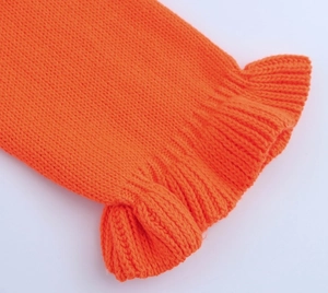 Détail du revers de manche en tricot orange vif avec volants étagés élégants