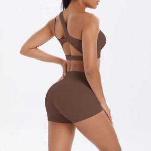 Detail of chocolate brown one-shoulder yoga set showing back cutout and high-waist fit