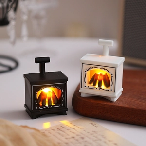 Close-up of mini vintage LED fireplace lamps with warm glowing coal effect in black and white