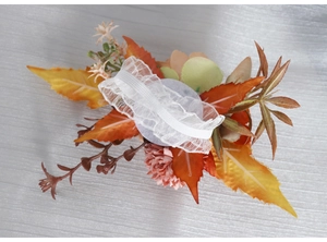 Detail of handmade wedding wrist corsage with lace elastic band and orange silk roses
