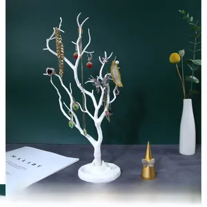 Detailed view of white tree-shaped jewelry organizer with multiple branches and round base