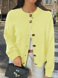 Détail d'un cardigan en maille jaune avec boutons marron et manches longues style décontracté