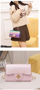 Detail of woven texture shoulder bag with iridescent finish and gold twist lock