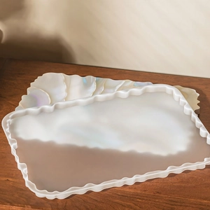 Set vassoio e sottobicchieri iridescenti con bordi a conchiglia su legno scuro decor
