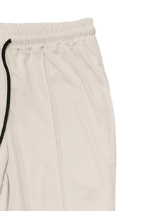 Detail of men's casual beige sports pants featuring elastic waist and black drawstring