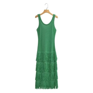 Détail d'une robe en tricot verte sans manches avec d'élégantes franges multicouches