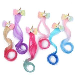 Detail of colorful unicorn hair clips with sequin bows and long synthetic wig extensions